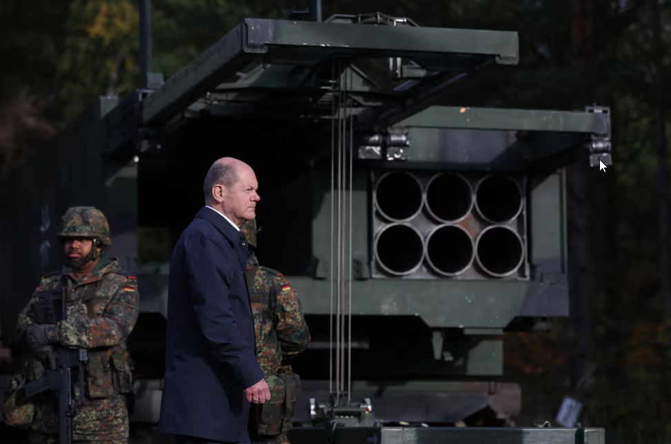 El Canciller alemán Olaf Scholz pasa por delante del Sistema de Lanzacohetes Múltiples (MARS II). Ilustración: AFP El Canciller alemán Olaf Scholz junto al Sistema de Lanzacohetes Múltiples (MARS II)