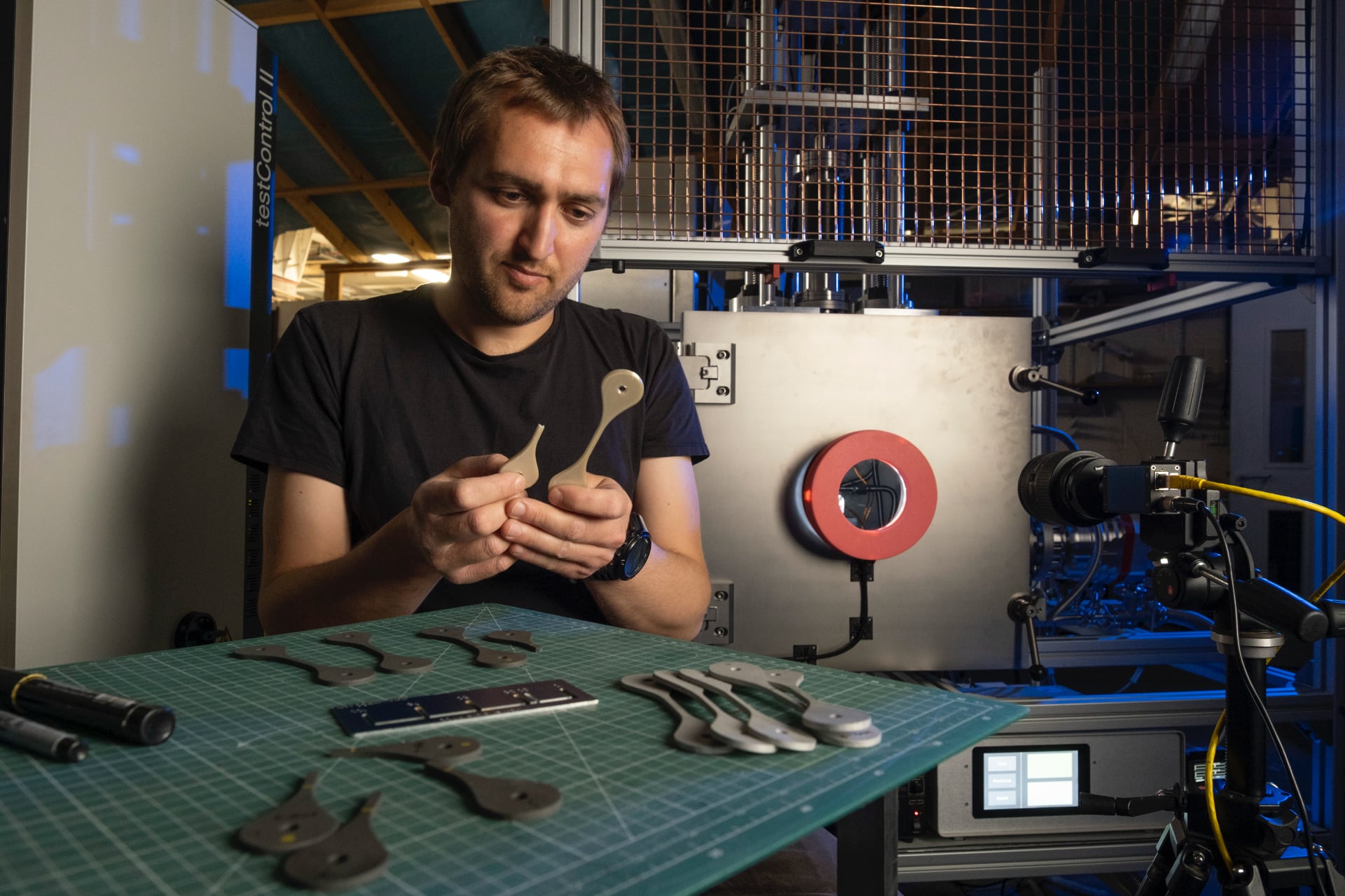 Charlie Patterson inspecciona muestras de material impreso en 3D probado en NextSpace TestRig